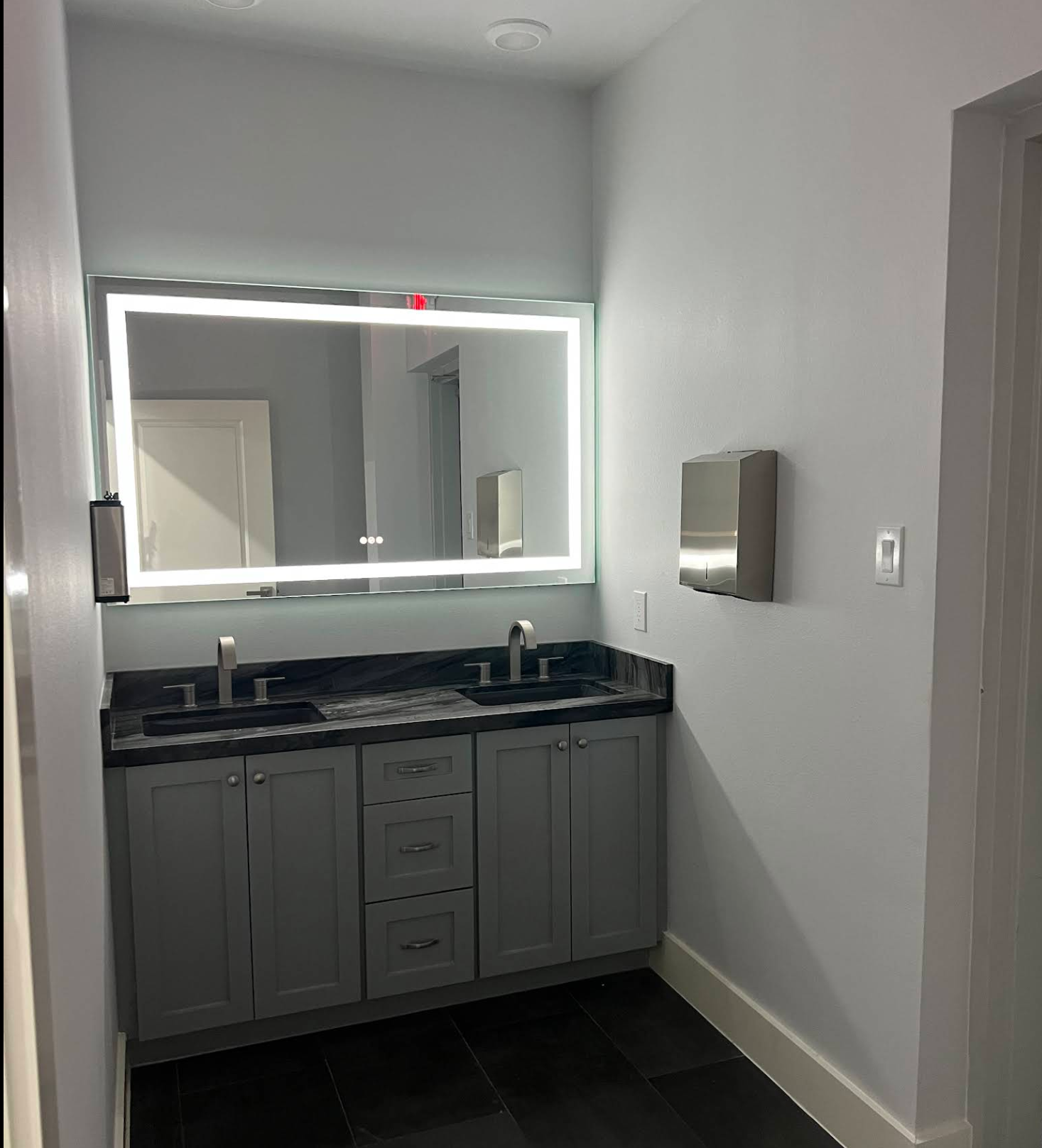 Clean restroom vanity with an illuminated mirror